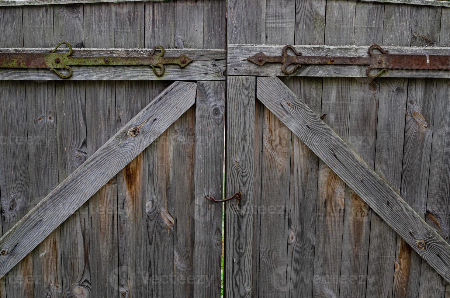 old weathered door in the wooden wall of an ancient hut photo