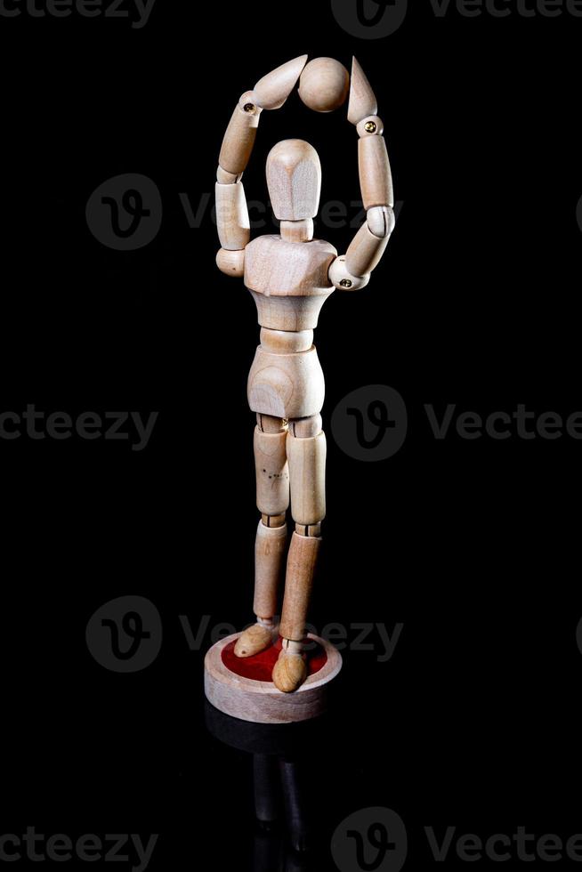 Image of wooden manikin on black background poses different posing photo