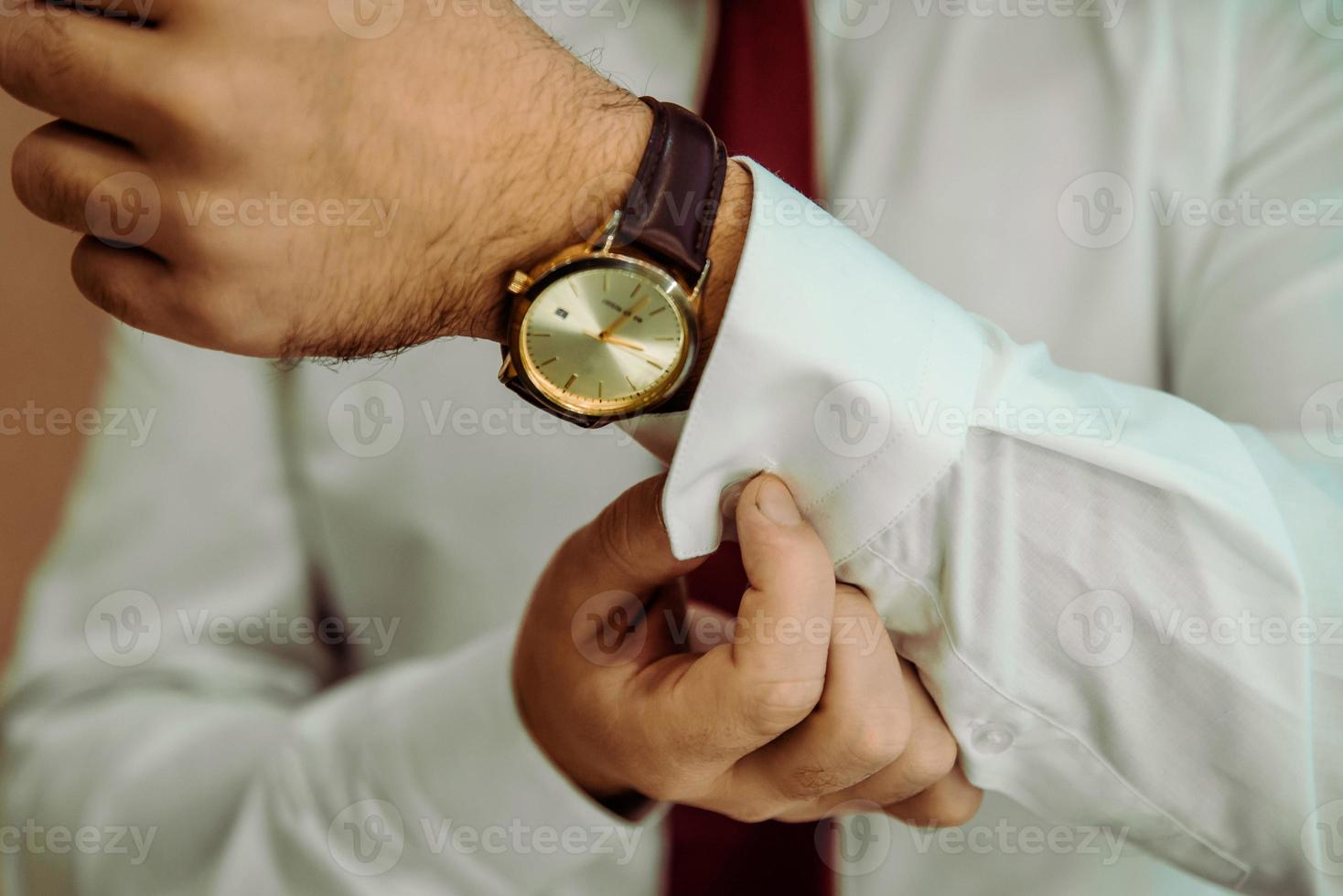 man putting clock on hand,groom getting ready in the morning photo