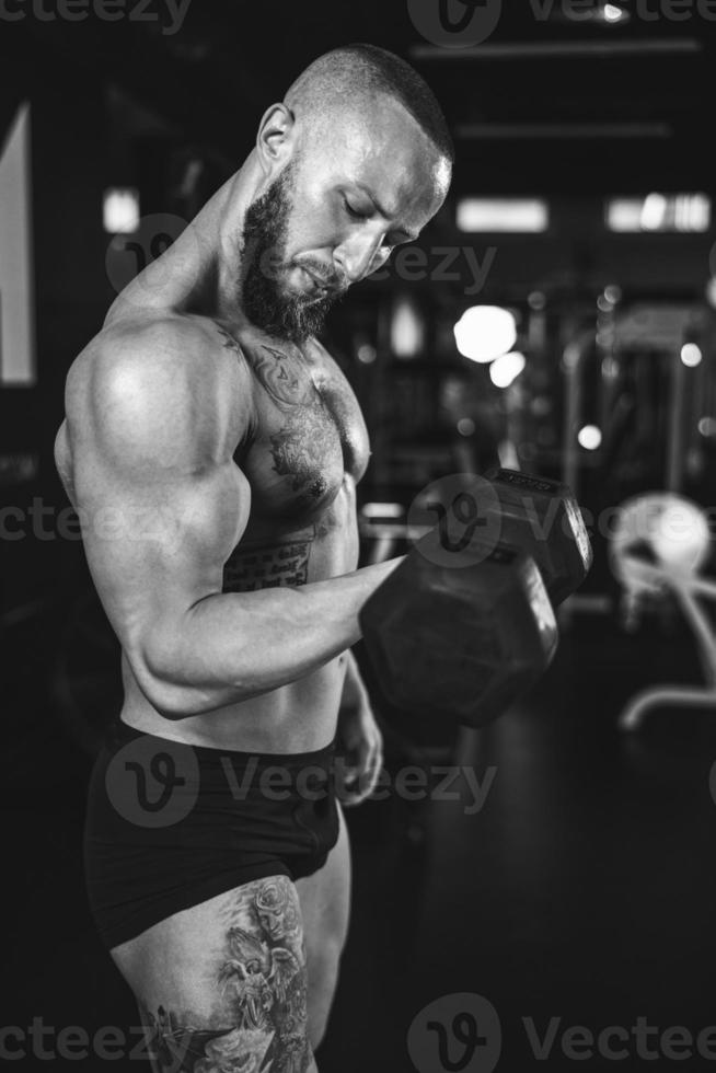 Man Doing Training With Dumbbell For His Arms Muscle At The Gym photo