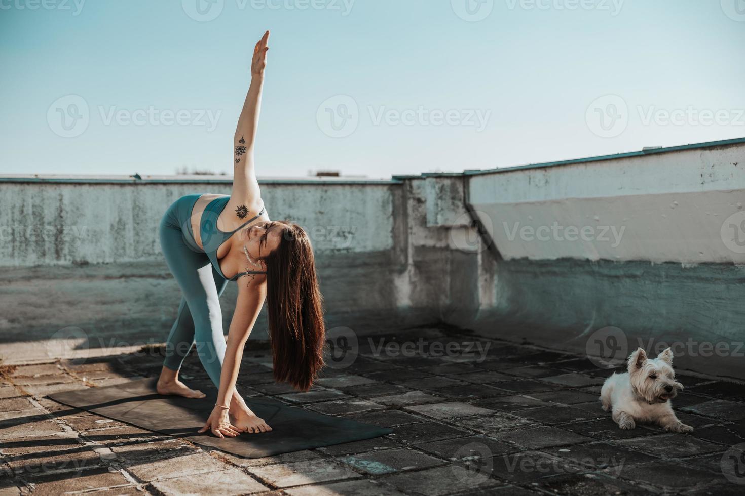 Woman Doing Yoga Outdoors On A Rooftop Terrace photo