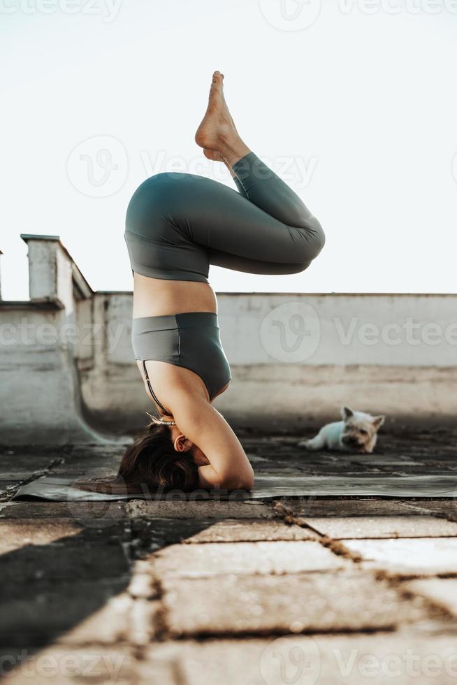 mujer haciendo yoga al aire libre en una terraza en la azotea foto