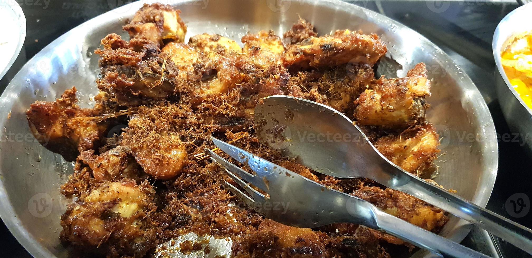 Ayam goreng rempah or traditional Javanese fried chicken, cooked on frying pan photo