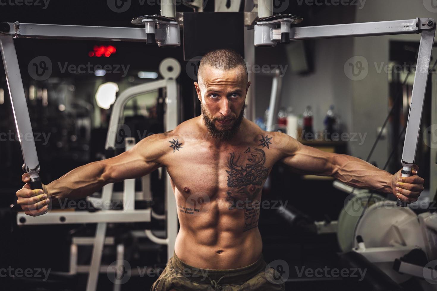 Man Doing Training On Machine For His Chest Muscle At The Gym photo