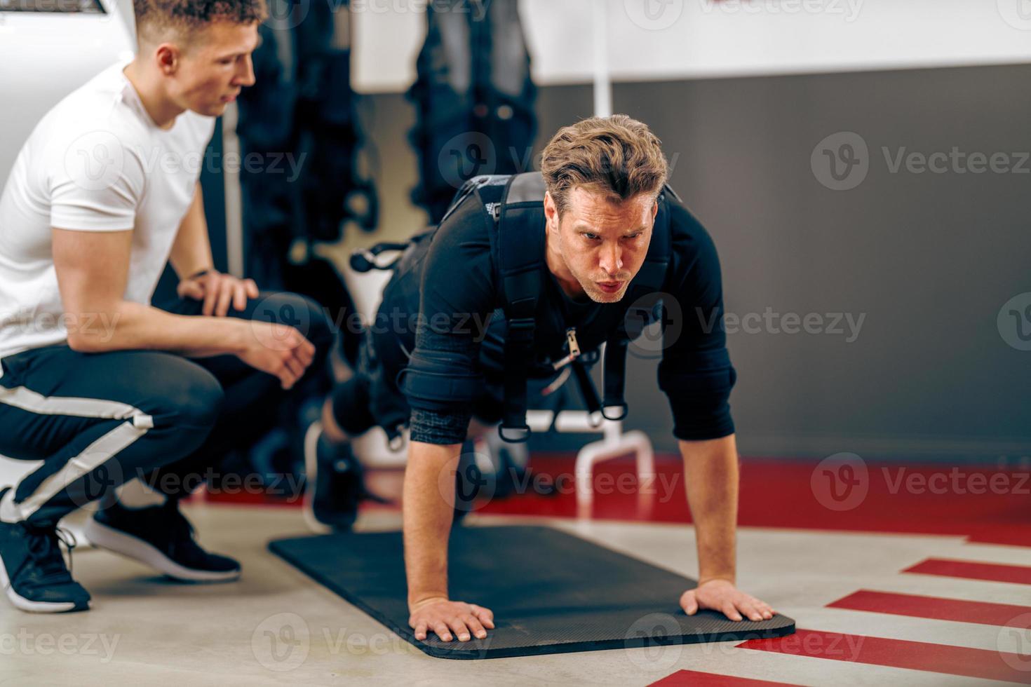 Man Doing Plank Exercise During EMS Workout In The Gym photo