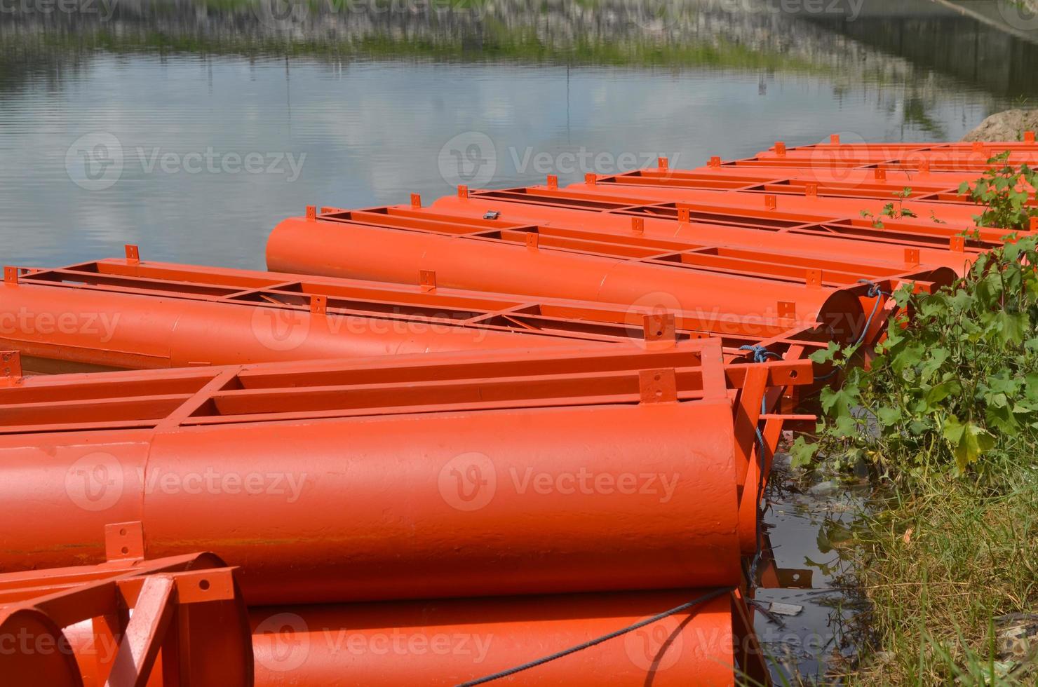 Stock photo of the orange iron tank drum barrier area on the edge of the reservoir