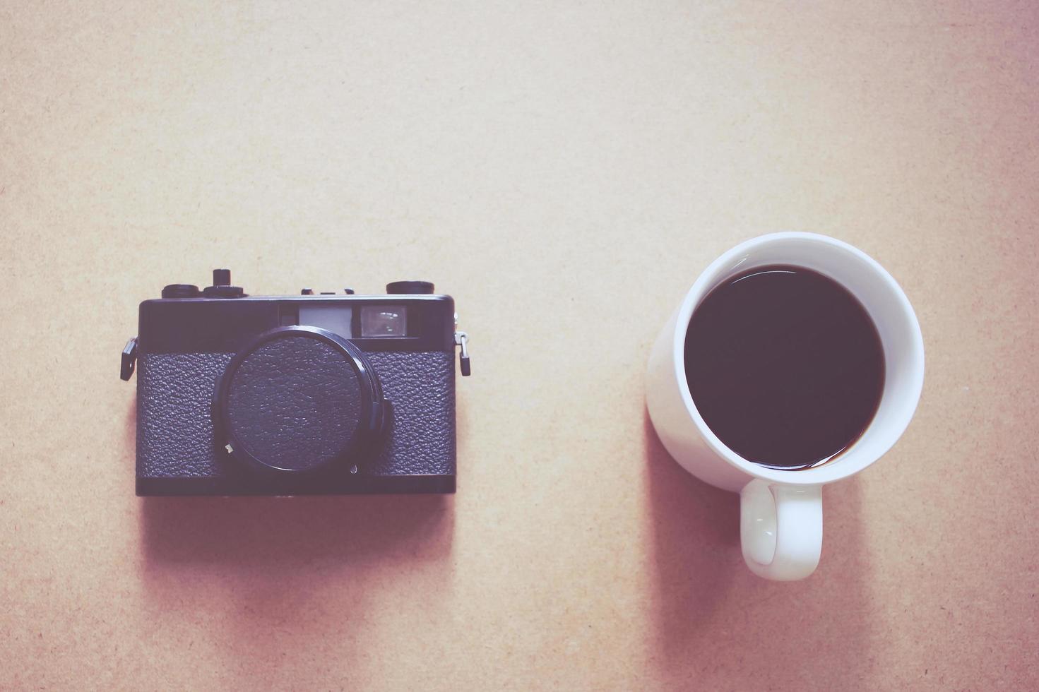 Vintage film camera and black coffee with retro filter effect photo