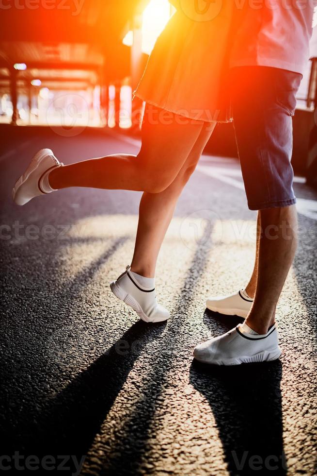 legs of a man and a woman at sunset photo