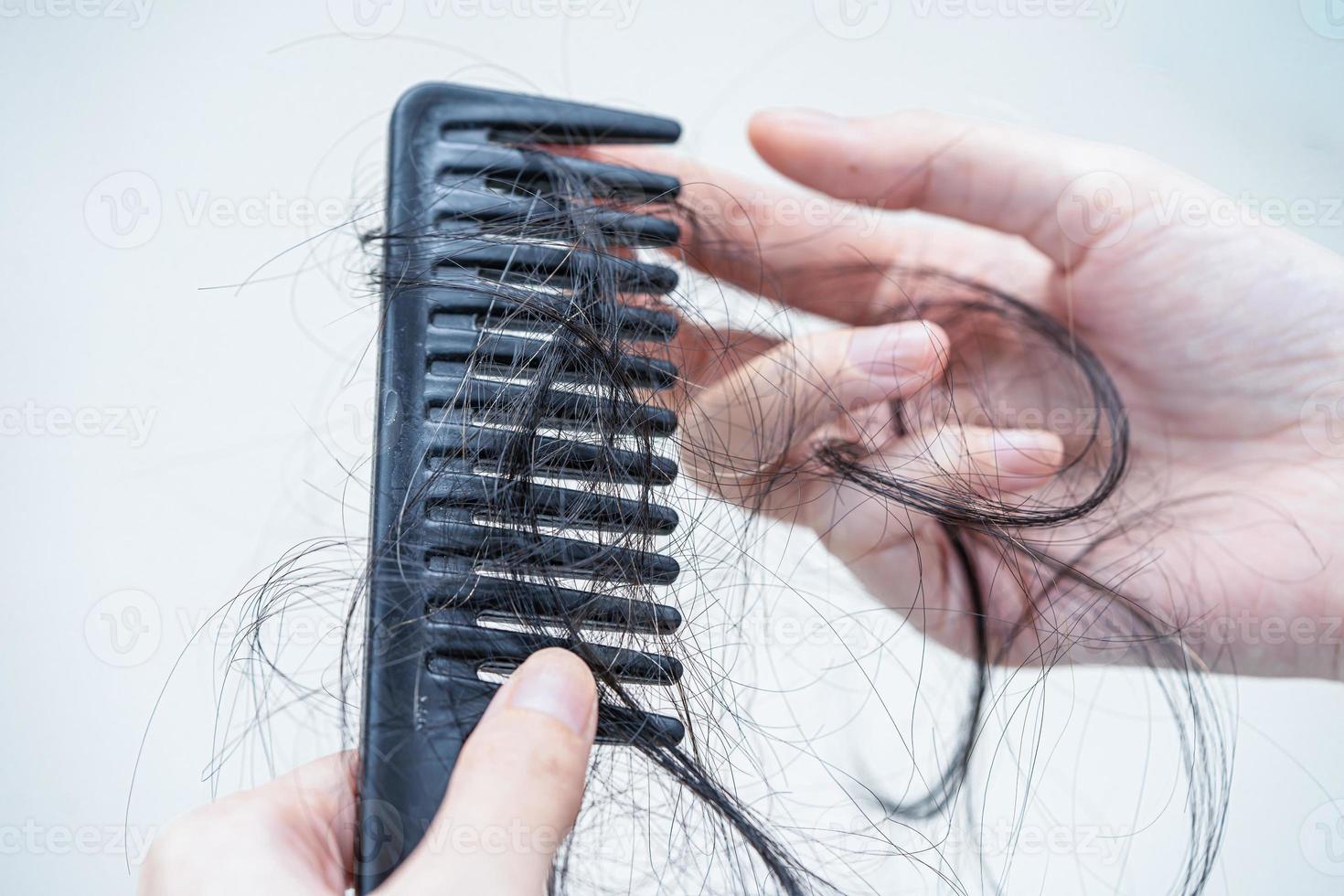 Asian woman have problem with long hair loss attach to comb brush. photo