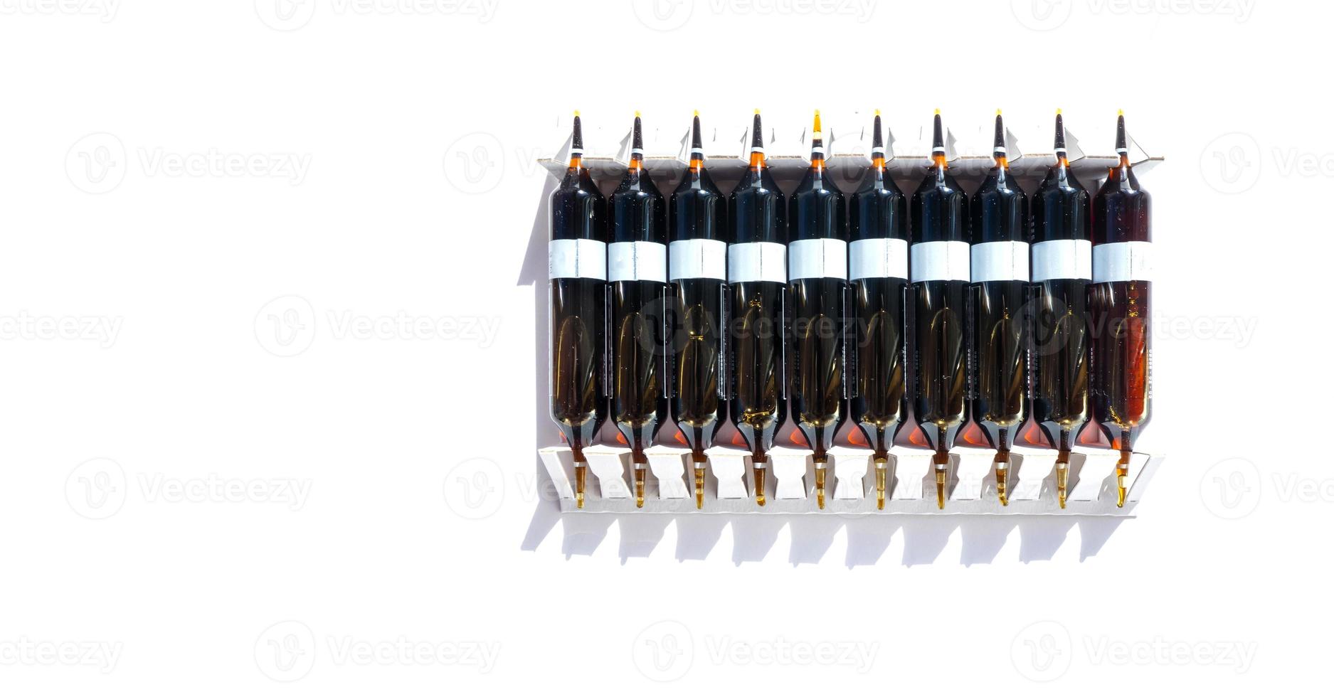 Group of ampoules with a transparent medicine in medical laboratory. lot of ampoules on light background. banner with copy space photo