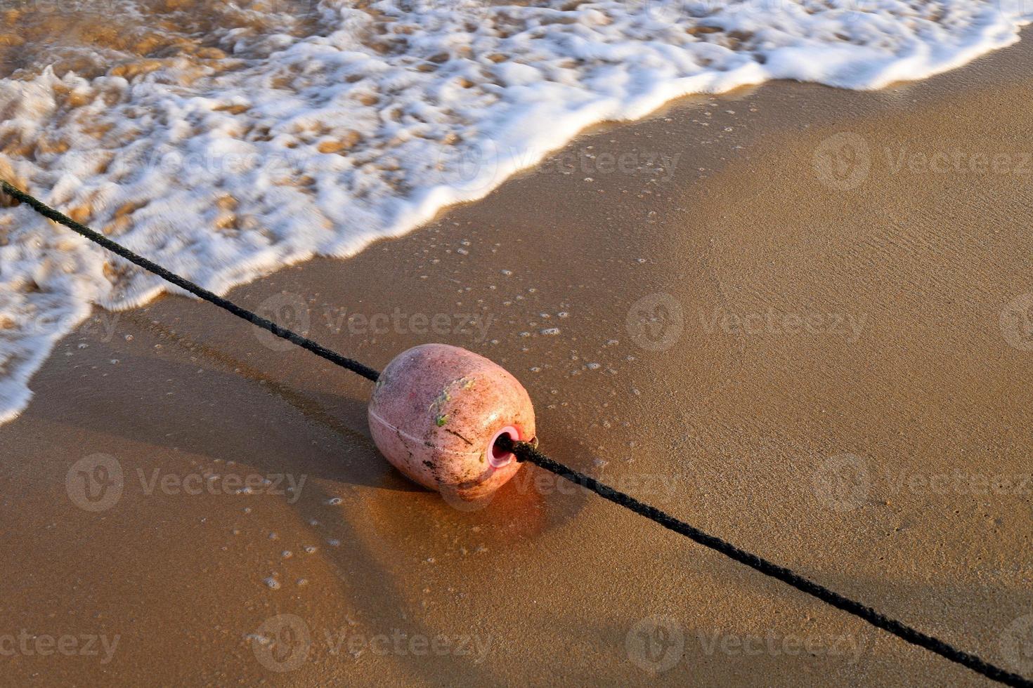 Hemp rope with buoys on the city beach photo