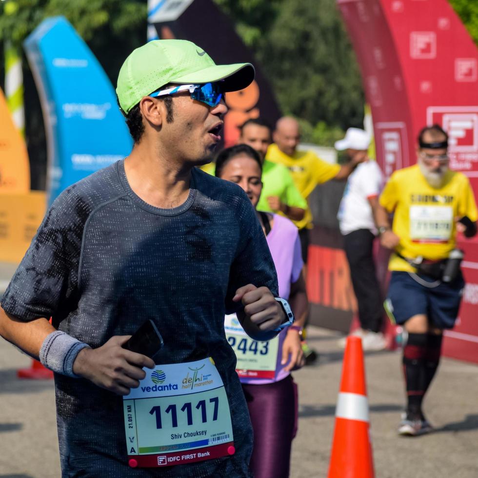 New Delhi, India - October 16 2022 - Vedanta Delhi Half Marathon race after covid in which marathon participants about to cross the finish line, Delhi Half Marathon 2022 photo