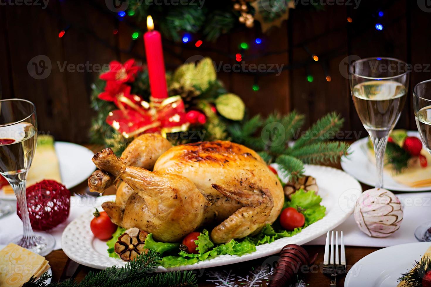 Baked turkey or chicken. The Christmas table is served with a turkey, decorated with bright tinsel and candles. Fried chicken, table. Christmas dinner. photo