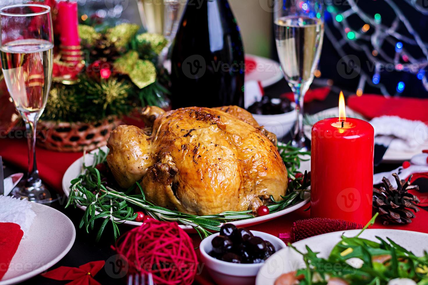 Baked turkey. Christmas dinner. The Christmas table is served with a turkey, decorated with bright tinsel and candles. Fried chicken, table.  Family dinner. photo