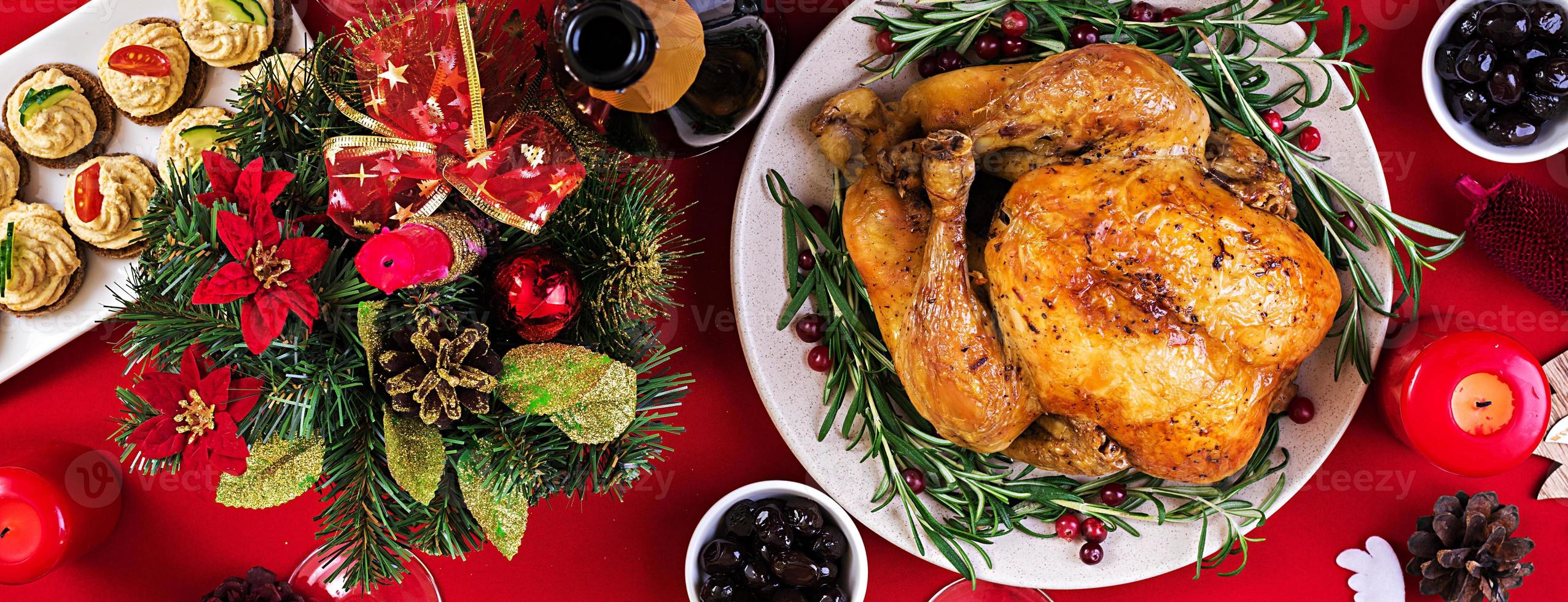 Baked turkey. Christmas dinner. The Christmas table is served with a turkey, decorated with bright tinsel and candles. Fried chicken, table.  Family dinner. Top view photo