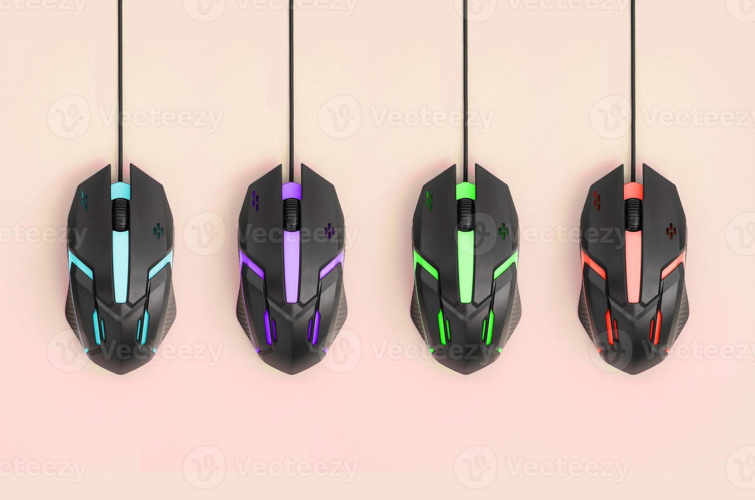 Black computer mouses hang on pastel peach background photo