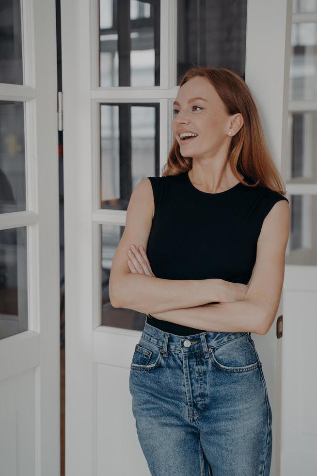 Smiling young caucasian woman in casual clothes on white door background laugh at funny joke at home photo