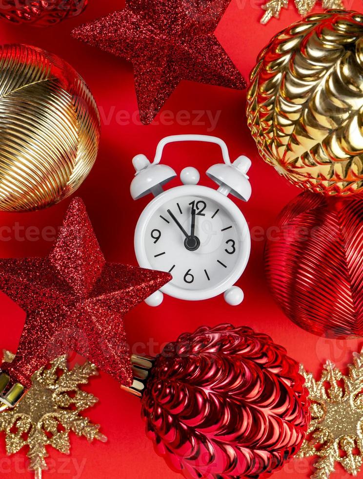 Happy New Year greeting card. Christmas and New Year decor. Christmas balls, stars and clocks on a bright red festive background photo