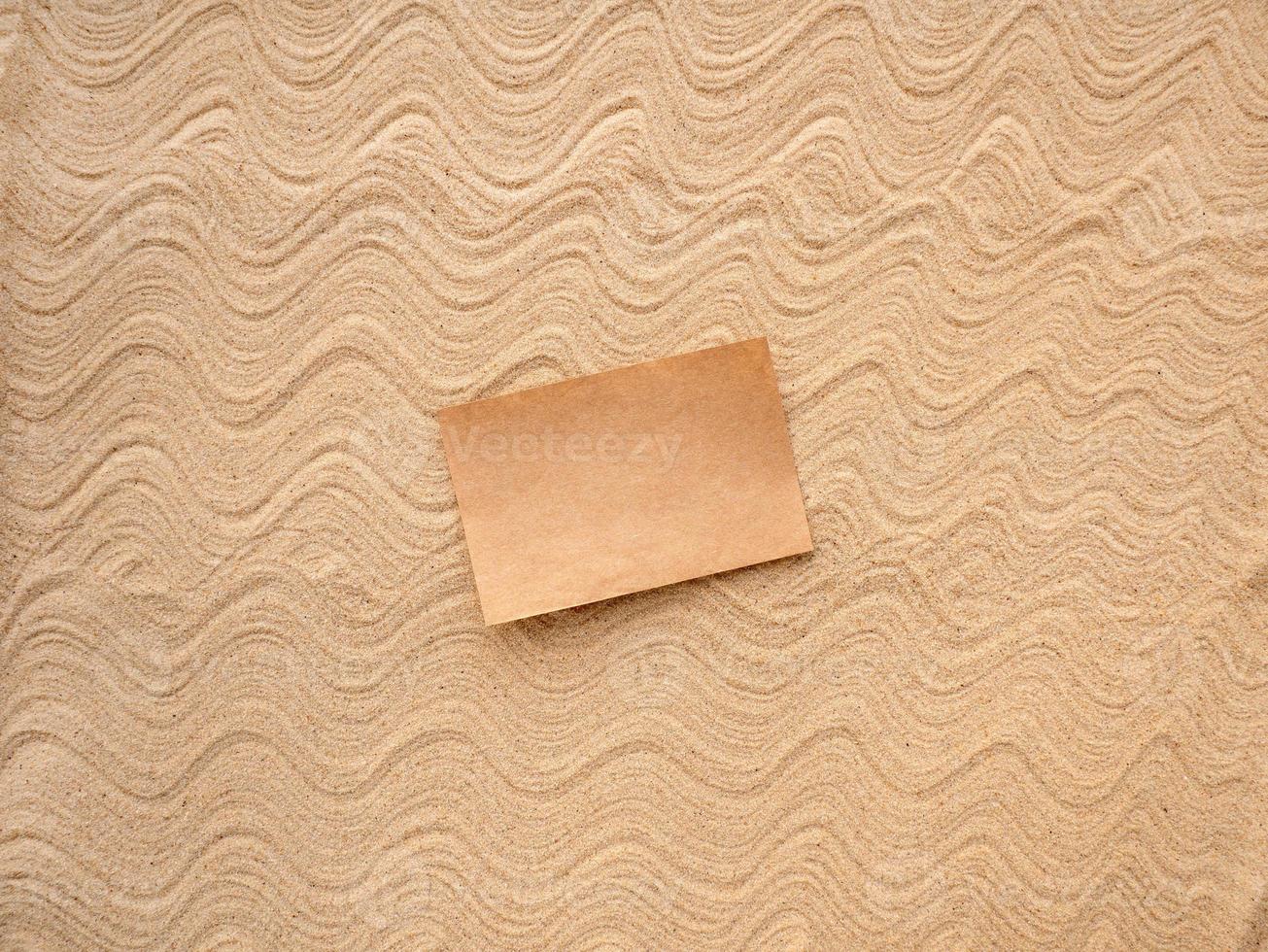 Letter in the sand. Craft paper for writing on patterned sea sand. photo