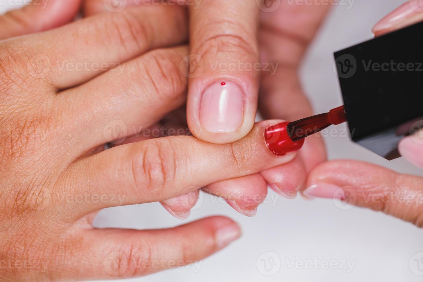 Woman Painting Nails And Enjoying Manicure Treatment At A Beauty Salon photo