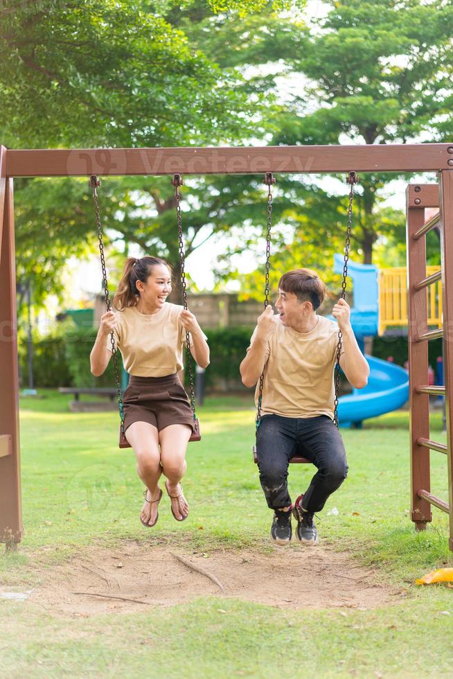 Pareja asiática ama jugar en el columpio foto