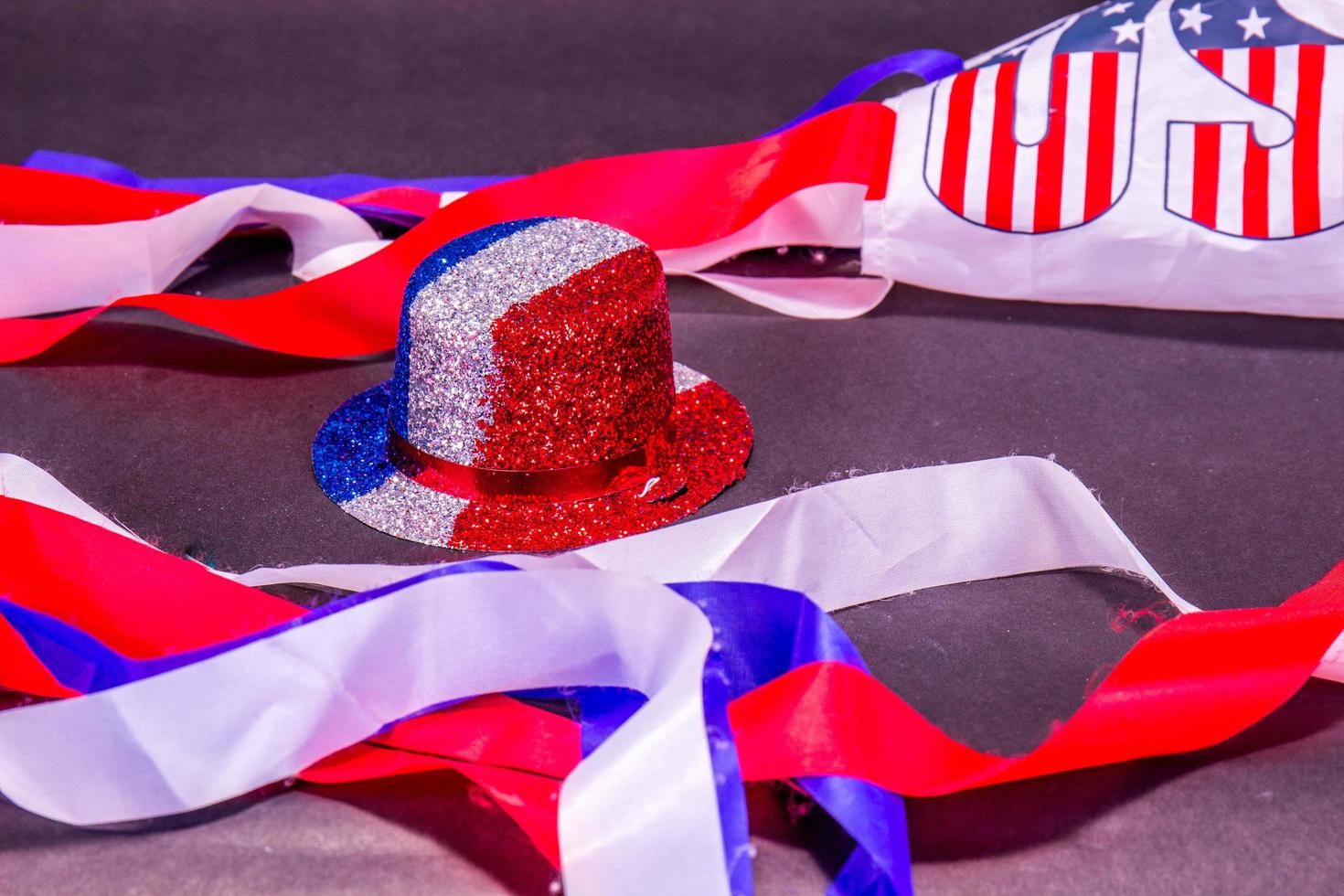 Red, White And Blue Party Top Hat In Middle Of American Flag Colored Streamer photo