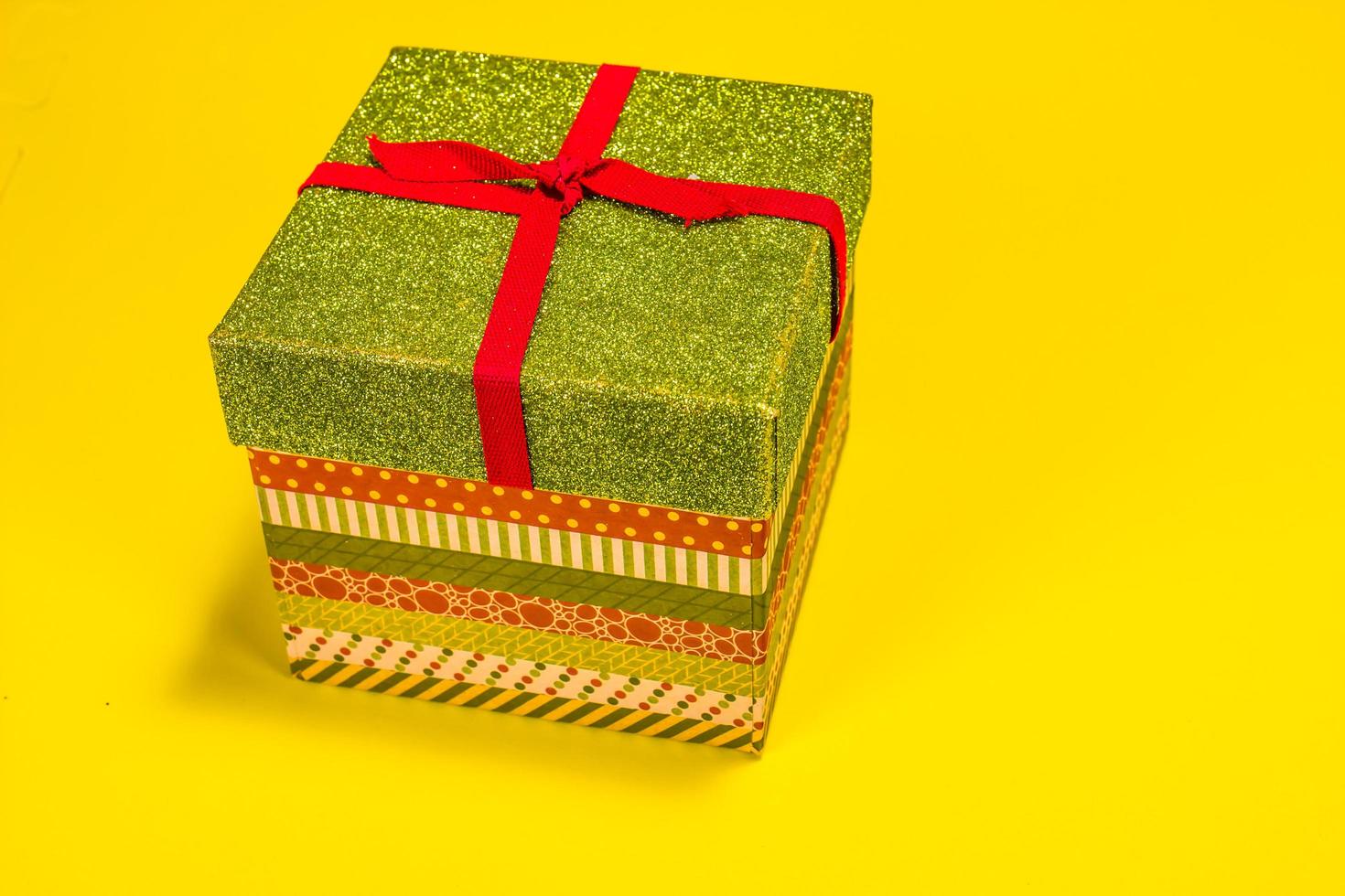Colorful Christmas Gift Box With Lid On Yellow Background photo