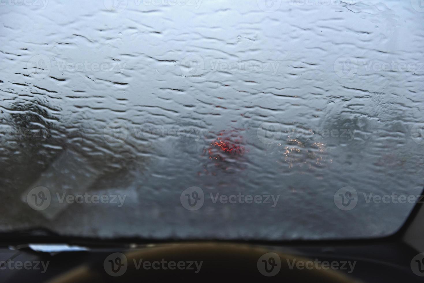 imagen borrosa de gotas de lluvia en el parabrisas. foto