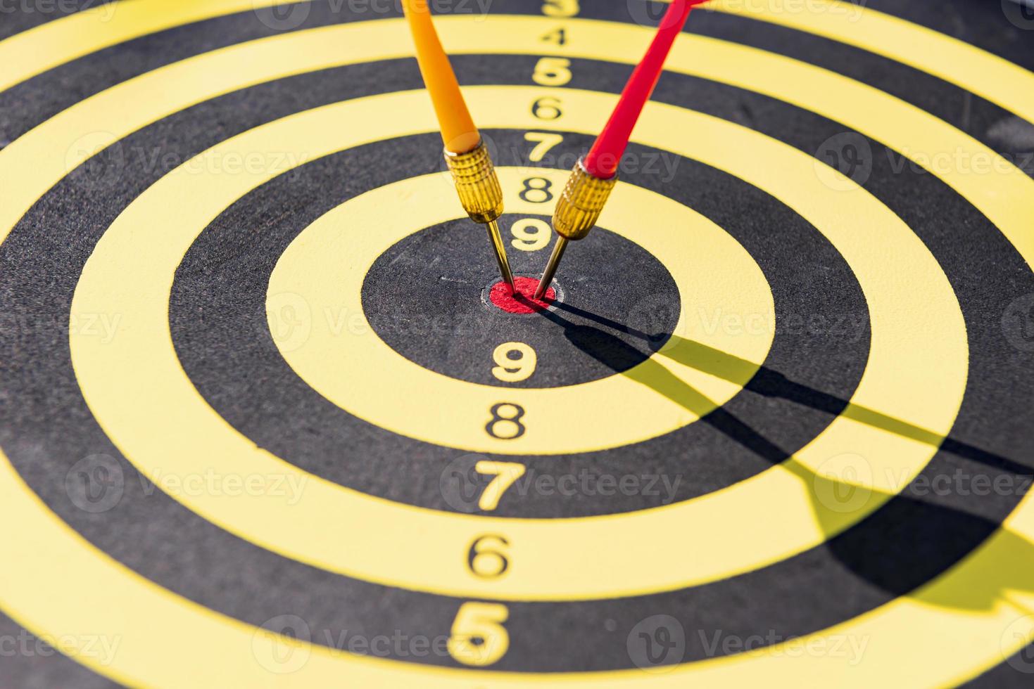 The dart board has yellow and red dart pins, the light that shines through them. photo
