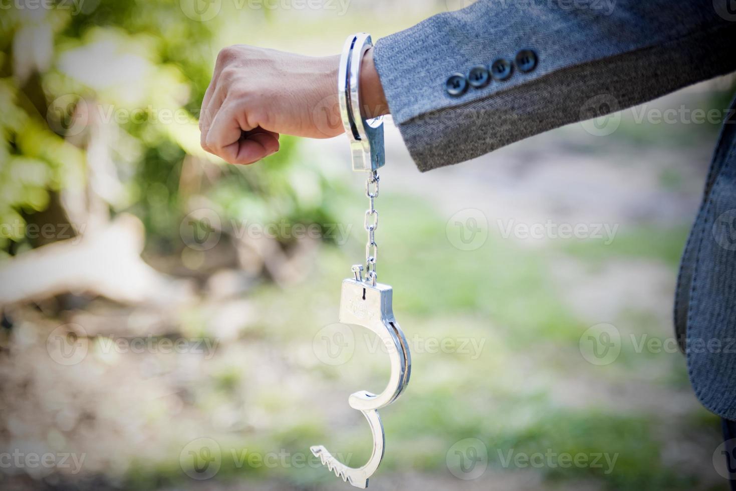 hand release shackle The man's handcuffs were opened. acquitted innocent defendant gray suit businessman cessation of criminal proceedings. photo
