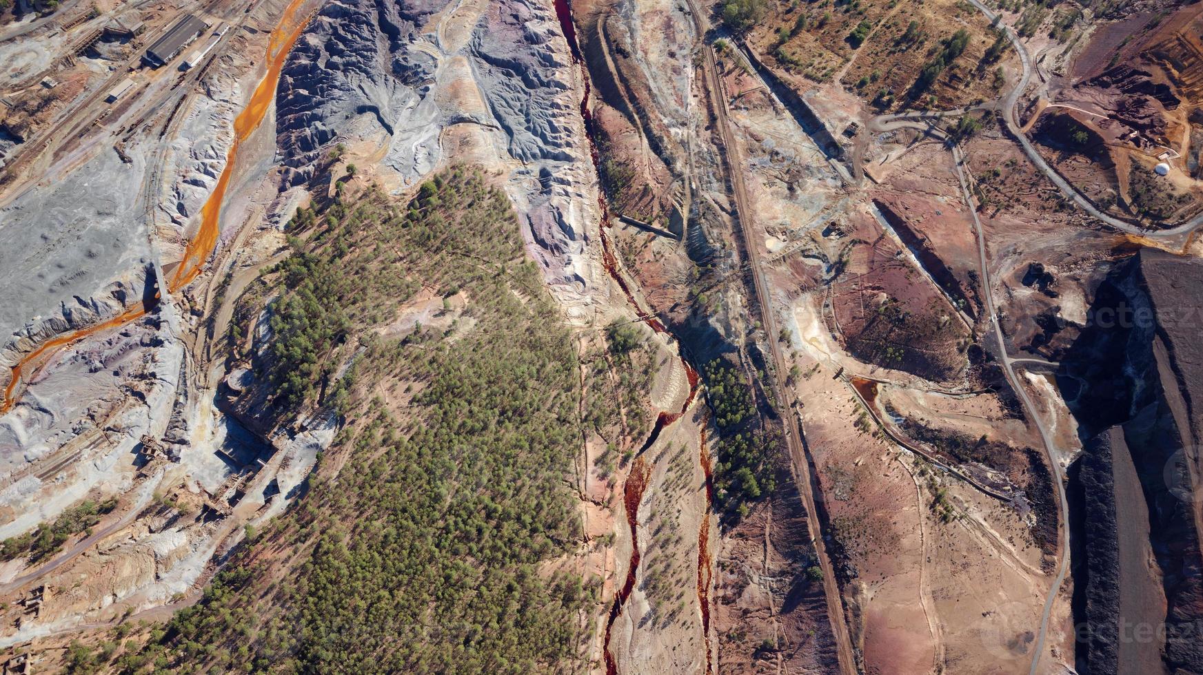 vista aérea de drones de la actividad minera en minas de riotinto en españa. río contaminado, color naranja del agua. paisaje de apocalipsis. extractivismo pueblo minero en andalucia. destrucción de la tierra. ruptura. foto