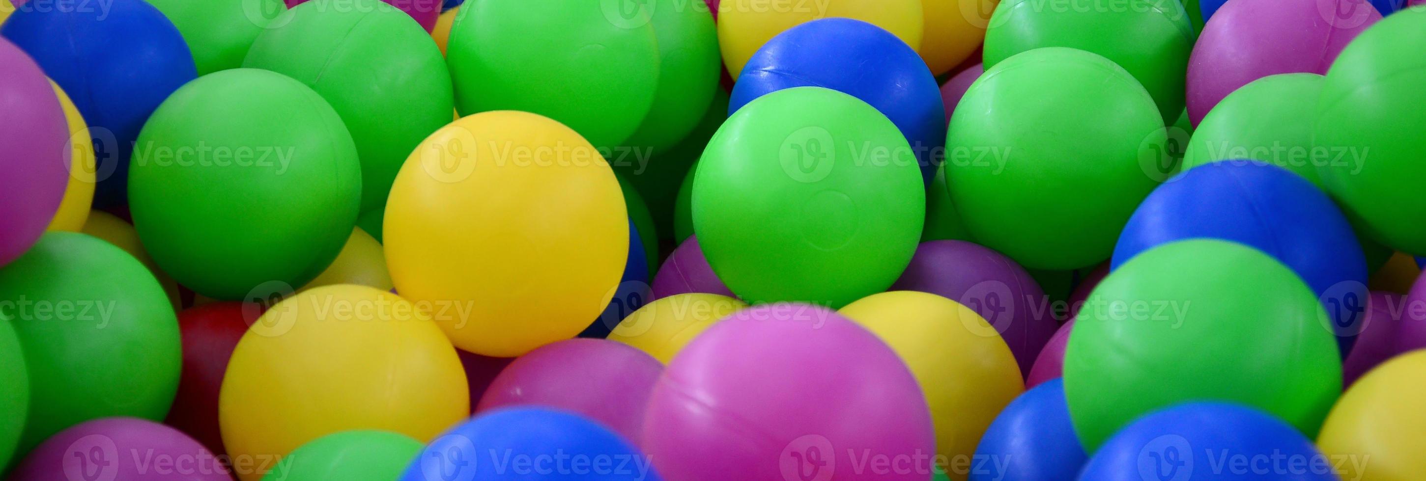 Swimming pool for fun and jumping in colored plastic balls photo