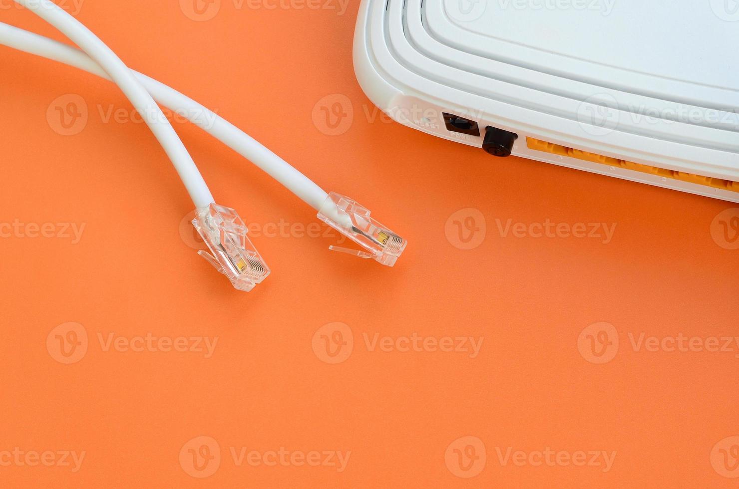 Internet router and Internet cable plugs lie on a bright orange background. Items required for Internet connection photo