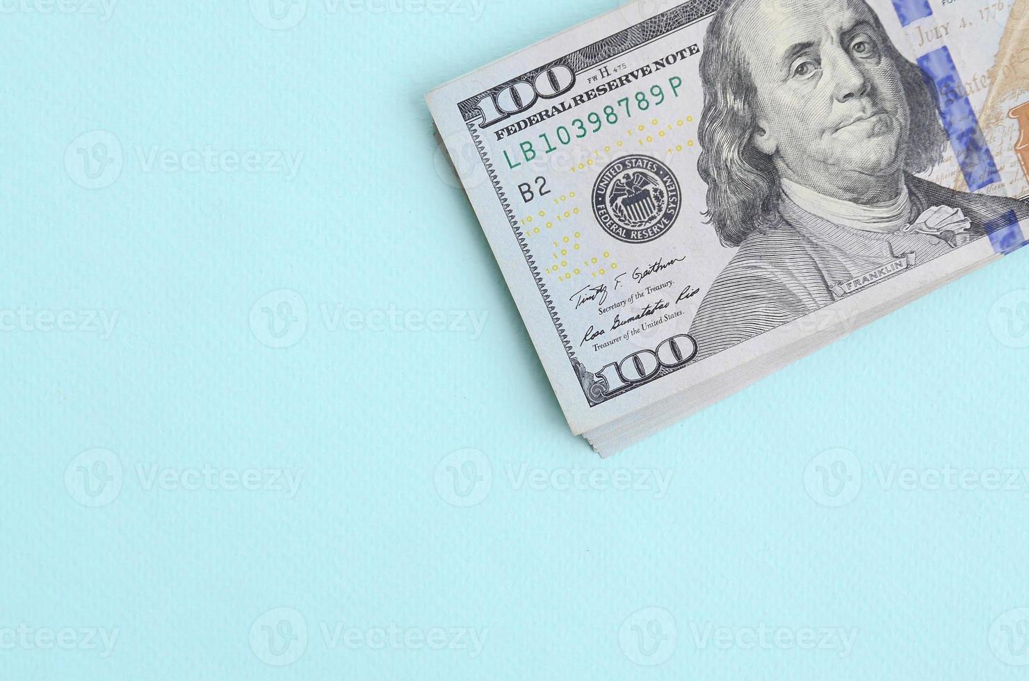 US dollar bills of a new design with a blue stripe in the middle is lies on a light blue background photo