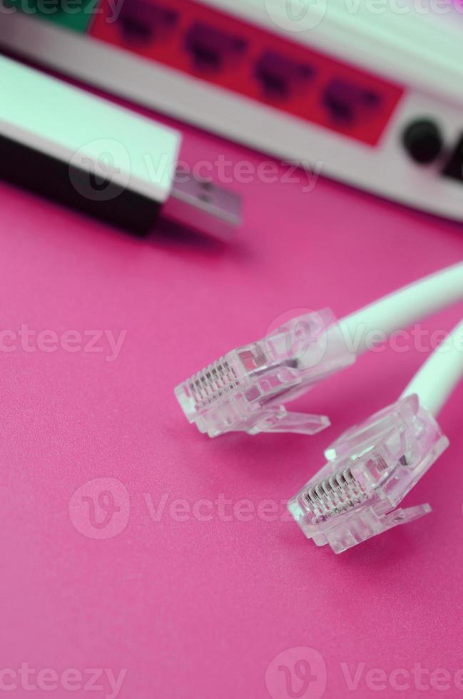 Internet router, portable USB wi-fi adapter and internet cable plugs lie on a bright pink background. Items required for internet photo