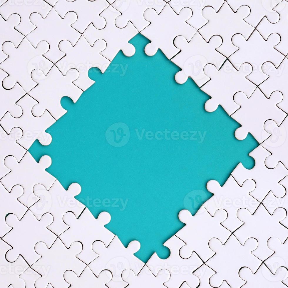 Framing in the form of a rhombus, made of a white jigsaw puzzle around the blue space photo