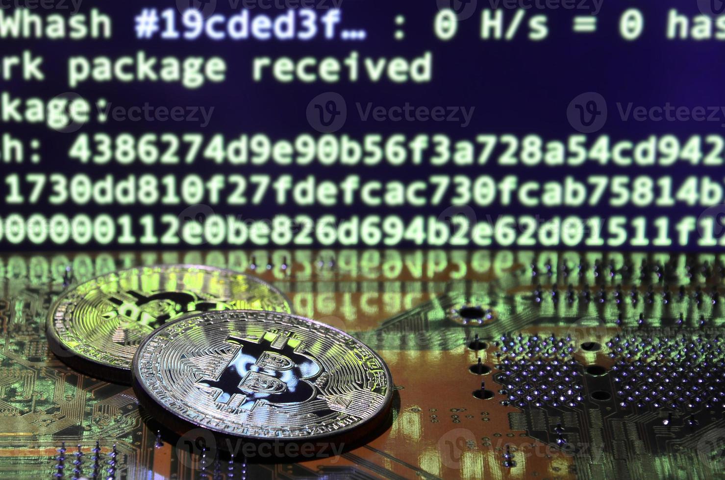 The digital process of cryptocurrency mining by using the GPUs. Bitcoins and video card on a working display and mining screen photo