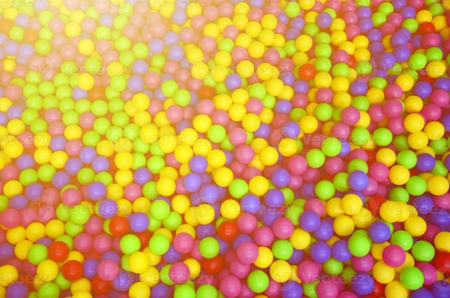 Many colorful plastic balls in a kids' ballpit at a playground. Close up pattern photo