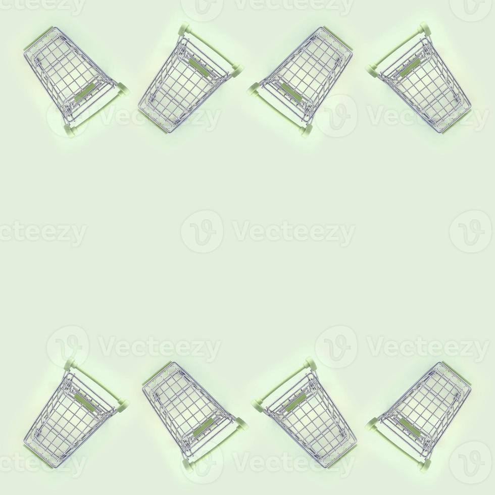 Pattern of many small shopping carts on a lime background photo