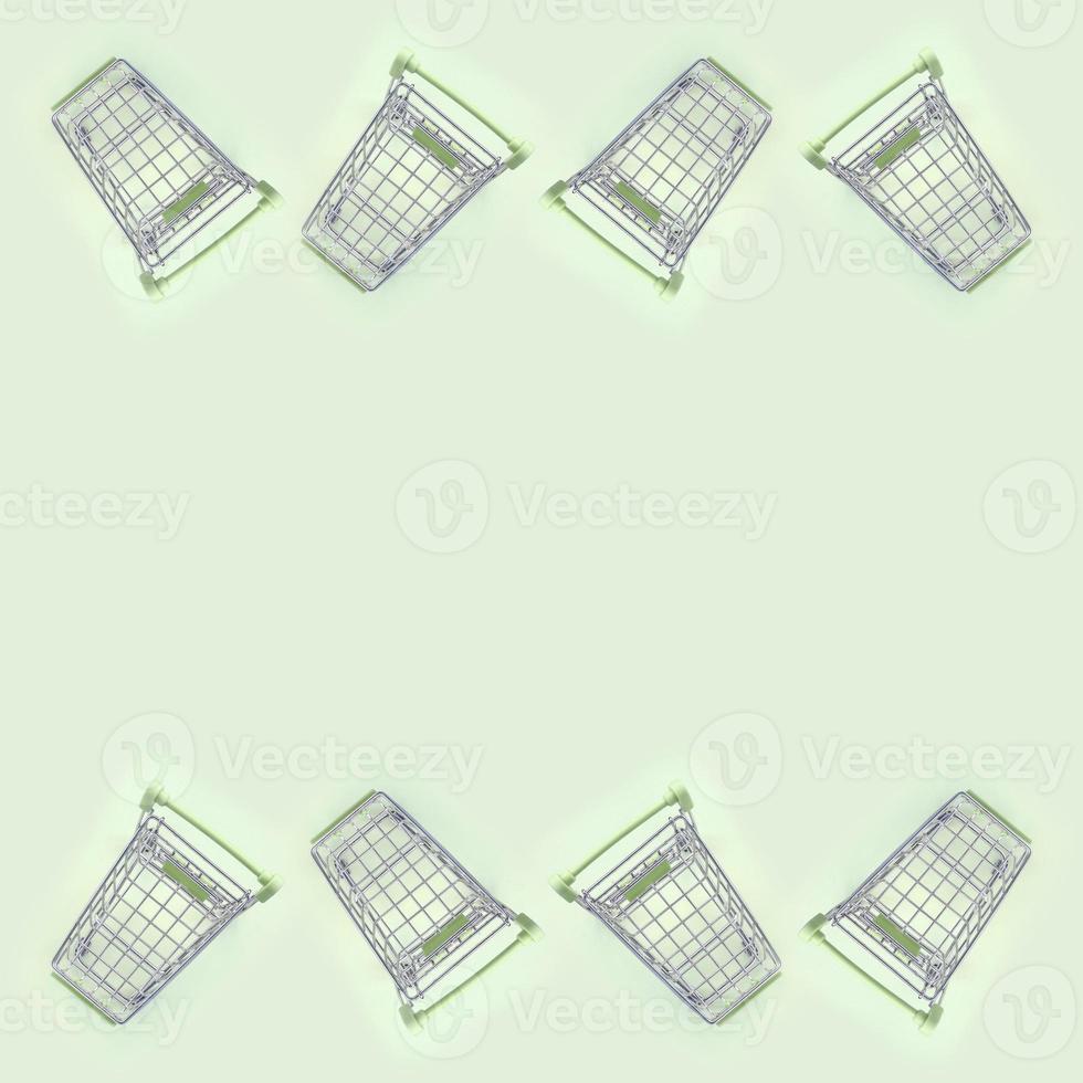 Pattern of many small shopping carts on a lime background photo