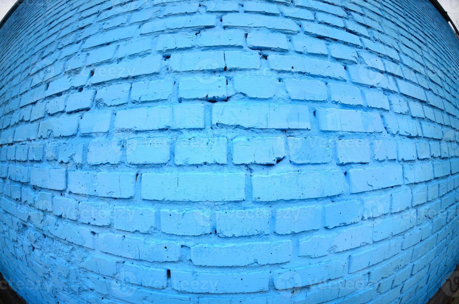 Large brick wall, painted in blue. Fisheye photo with pronounced distortion