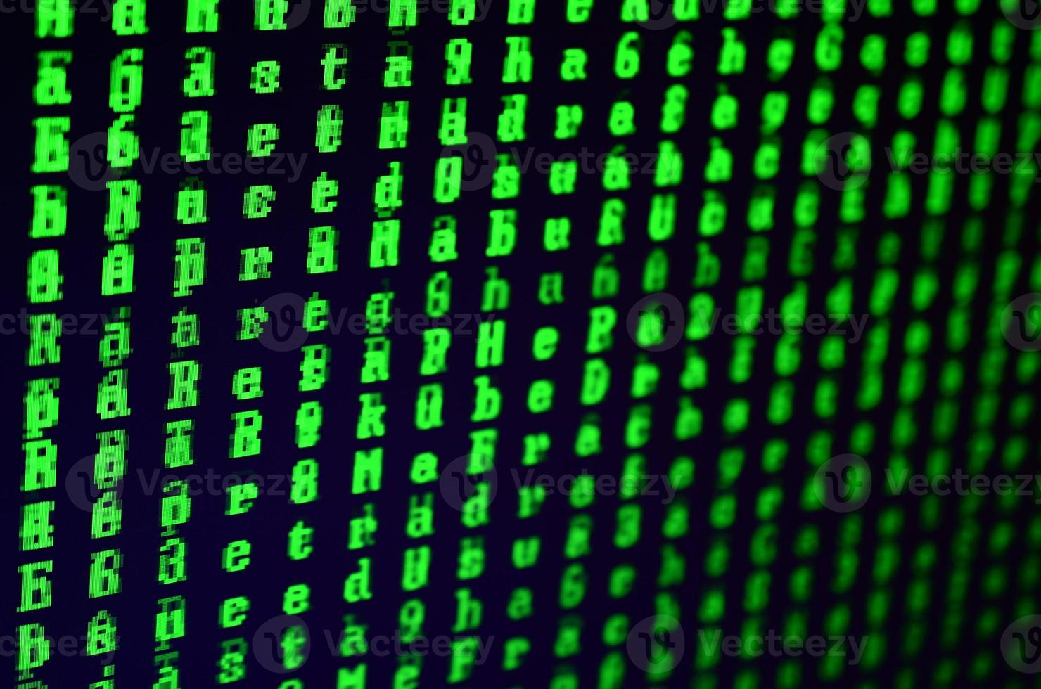 Macro shot of a glitch on the monitor of an office computer. The concept of introducing a virus into a personal data keeper. Stream of random green symbols on a black background photo