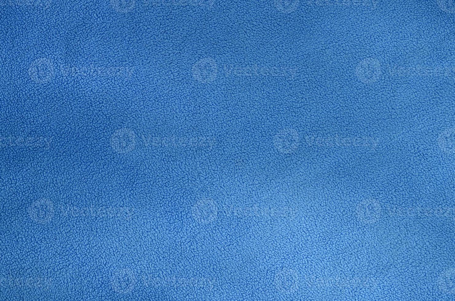 The blanket of furry blue fleece fabric. A background texture of light blue soft plush fleece material photo