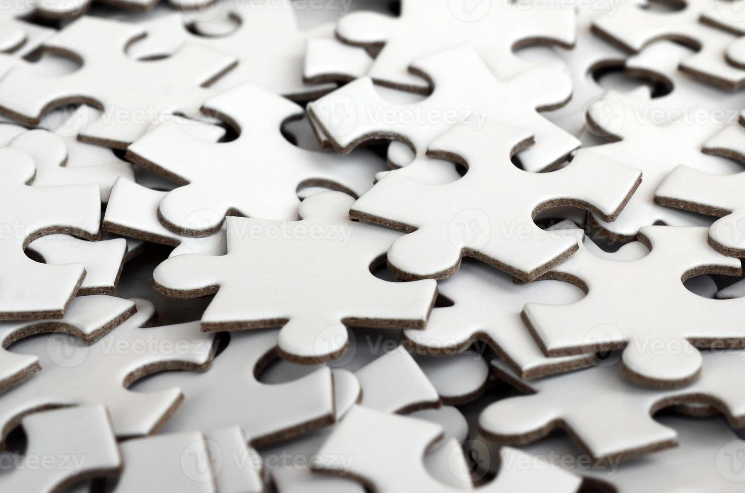 Close-up of a pile of uncompleted elements of a white puzzle. A huge number of rectangular pieces from one large white mosaic photo