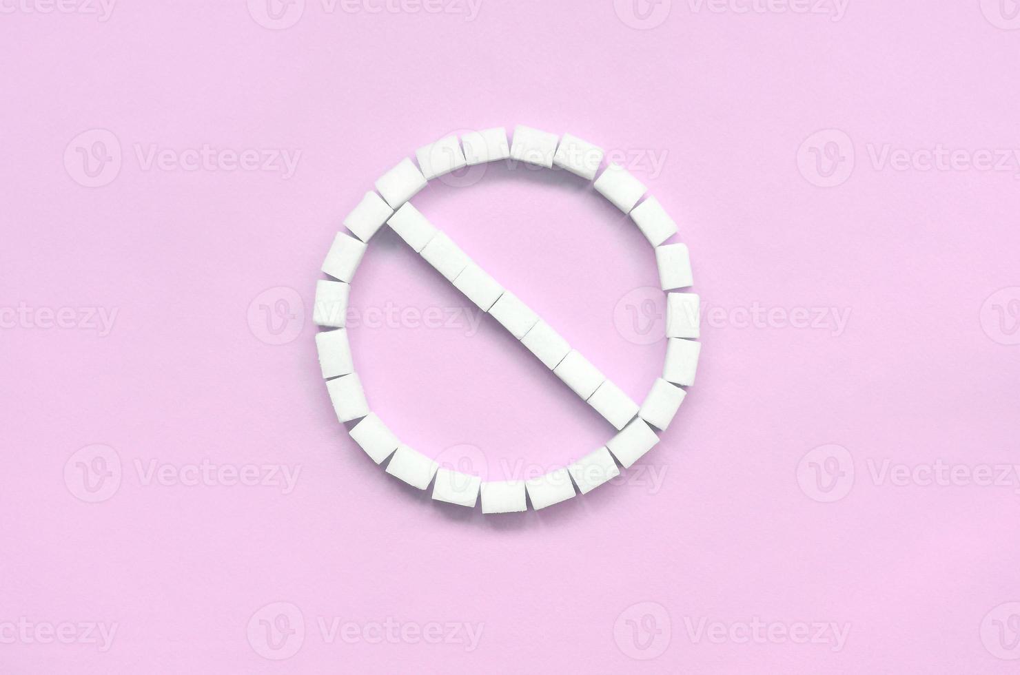 Sign of the ban of sugar cubes on a pastel pink background photo