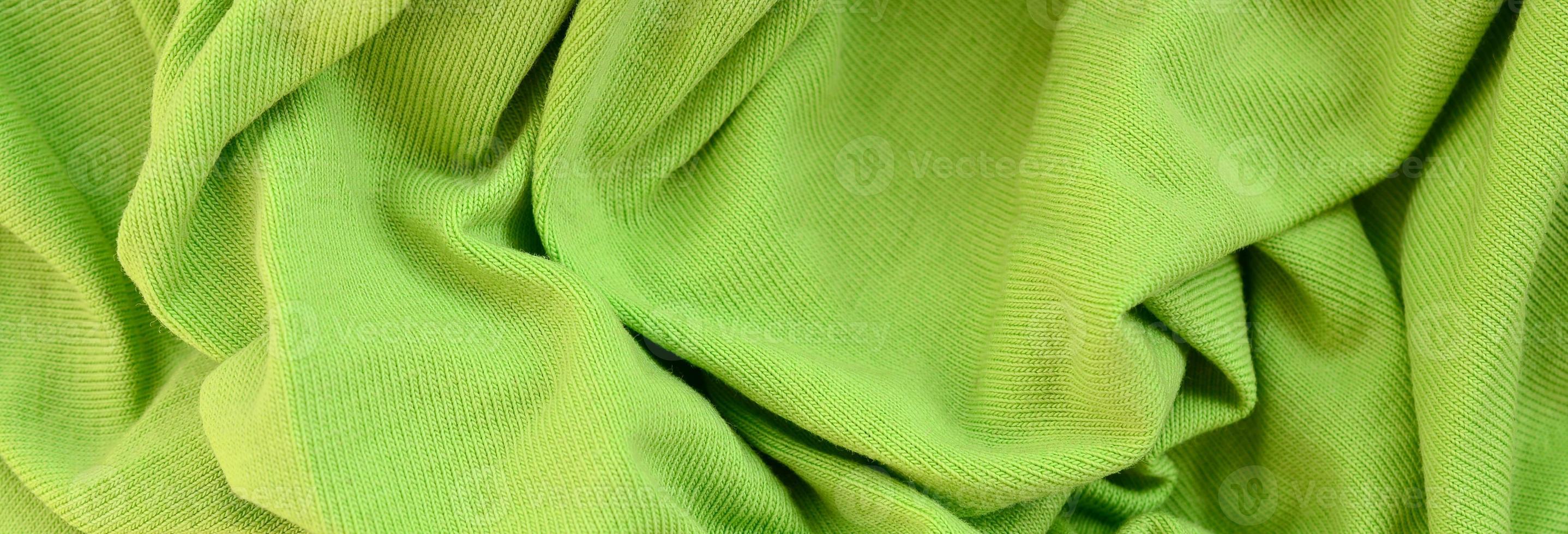 The texture of the fabric is bright green. Material for making shirts and blouses photo