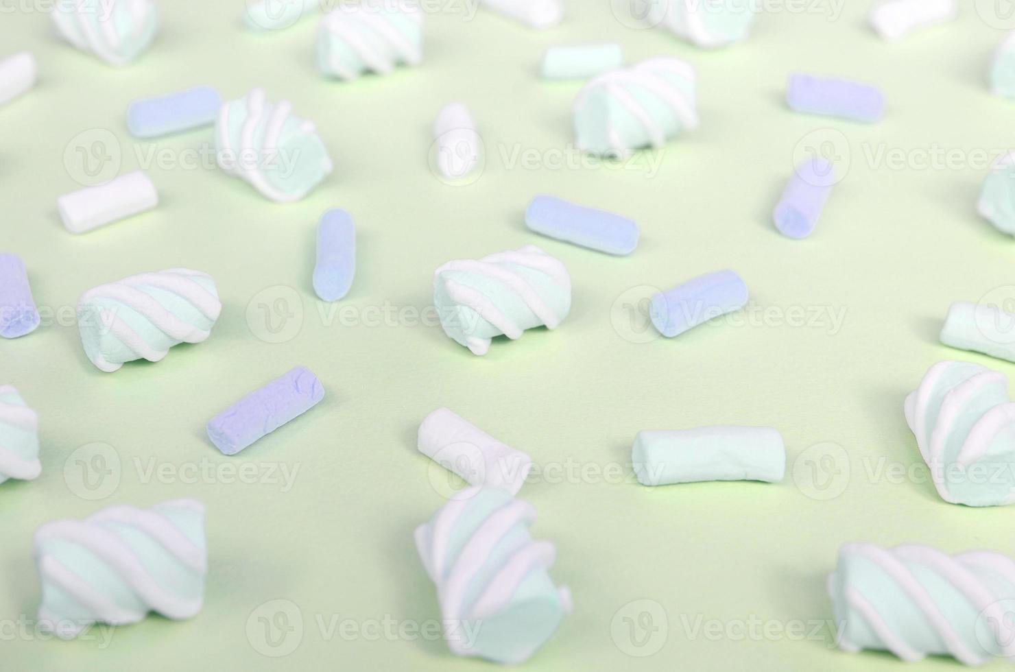 Colorful marshmallow laid out on lime paper background. pastel creative textured pattern photo