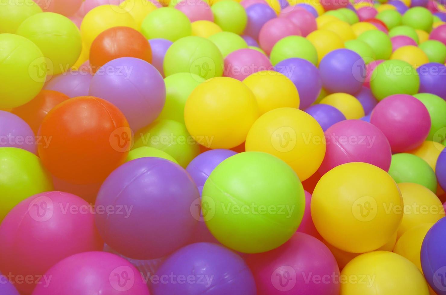 Many colorful plastic balls in a kids' ballpit at a playground. Close up pattern photo