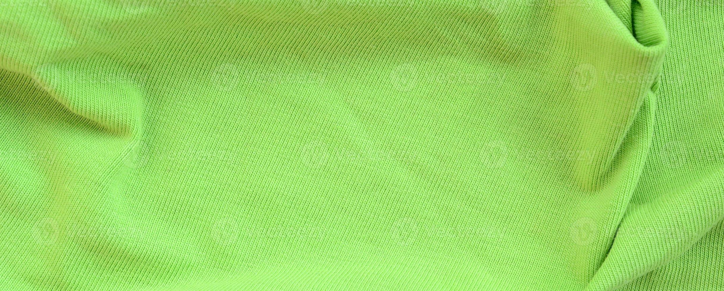 The texture of the fabric is bright green. Material for making shirts and blouses photo