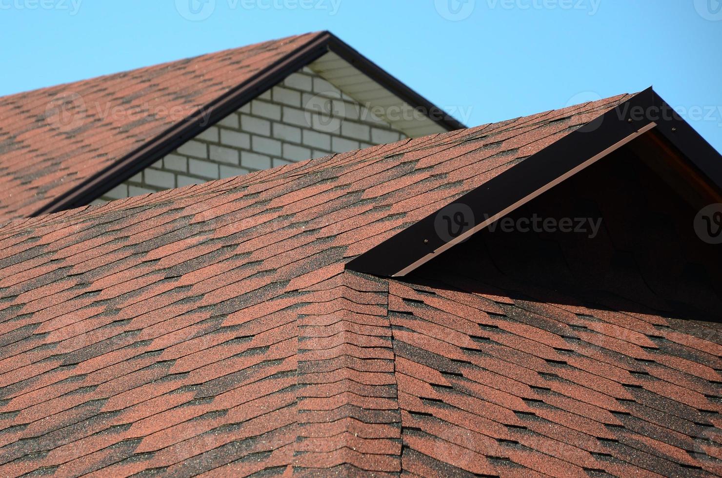 The roof is covered with bituminous shingles of brown color. Quality Roofing photo